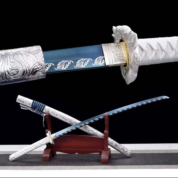 Angel Wings katana replica — blue T10 carbon steel blade with wing pattern, silver tsuba with gold trim, white-wrapped handle, silver engraved saya on wooden stand