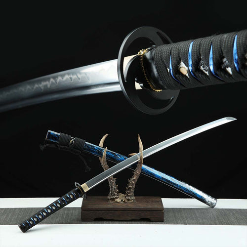 Tokyo katana replica — steel blade with hamon, black ito with blue accents, black tsuba, marbled blue-black saya on antler stand
