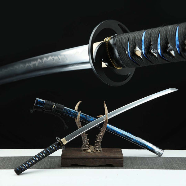 Tokyo katana replica — steel blade with hamon, black ito with blue accents, black tsuba, marbled blue-black saya on antler stand